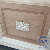 Dettaglio di intarsio artigianale su anta grezza in legno della Collezione Arte di Piombini, con decoro floreale centrale e cornice a filetto. Eccellenza della falegnameria italiana, simbolo di tradizione e maestria per il centenario 1925-2025.
